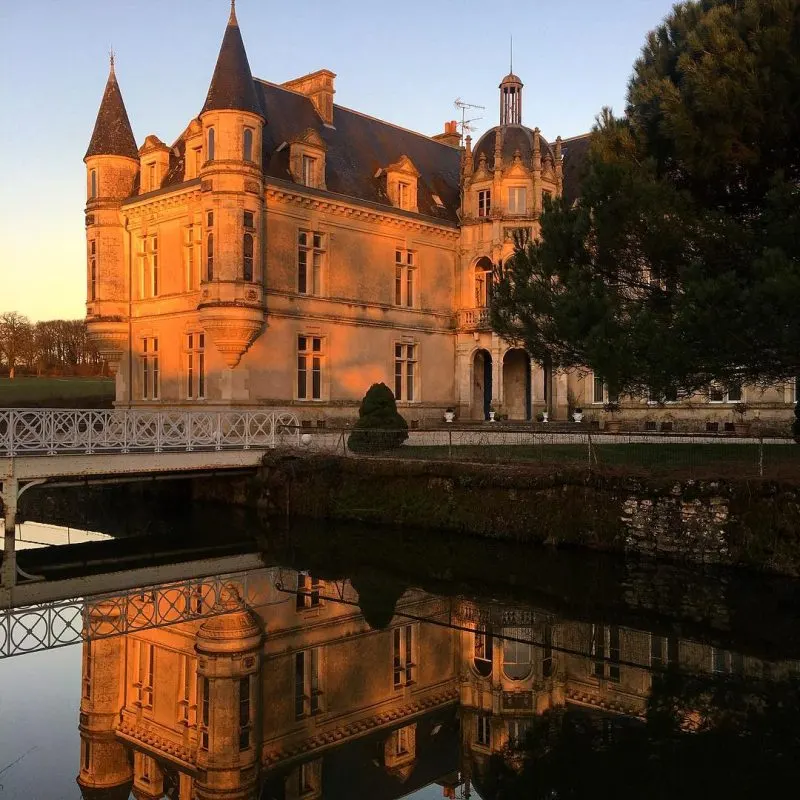 Le château au coucher du soleil, reflété dans les douves