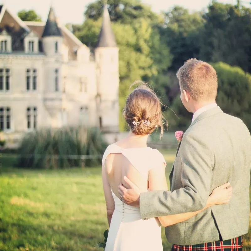 Un couple de mariés face au château