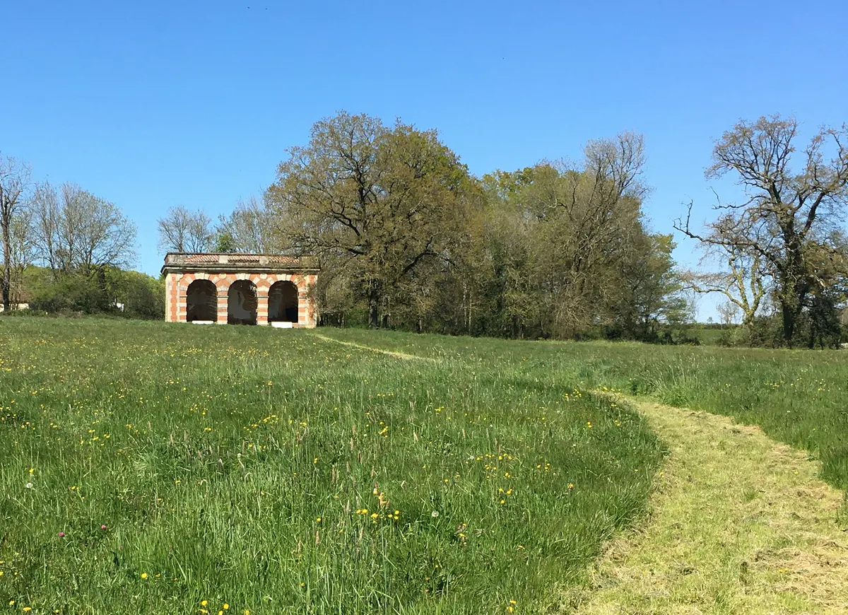 Les ruines de l'orangerie au milieu de la prairie